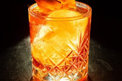 clear drinking glass with orange liquid and ice